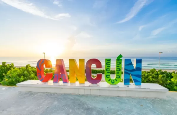 Durante el tour Cancun Mayan Discovery conocerás la Playa Delfines y podrás tomarte fotos en el icónico letrero de Cancún